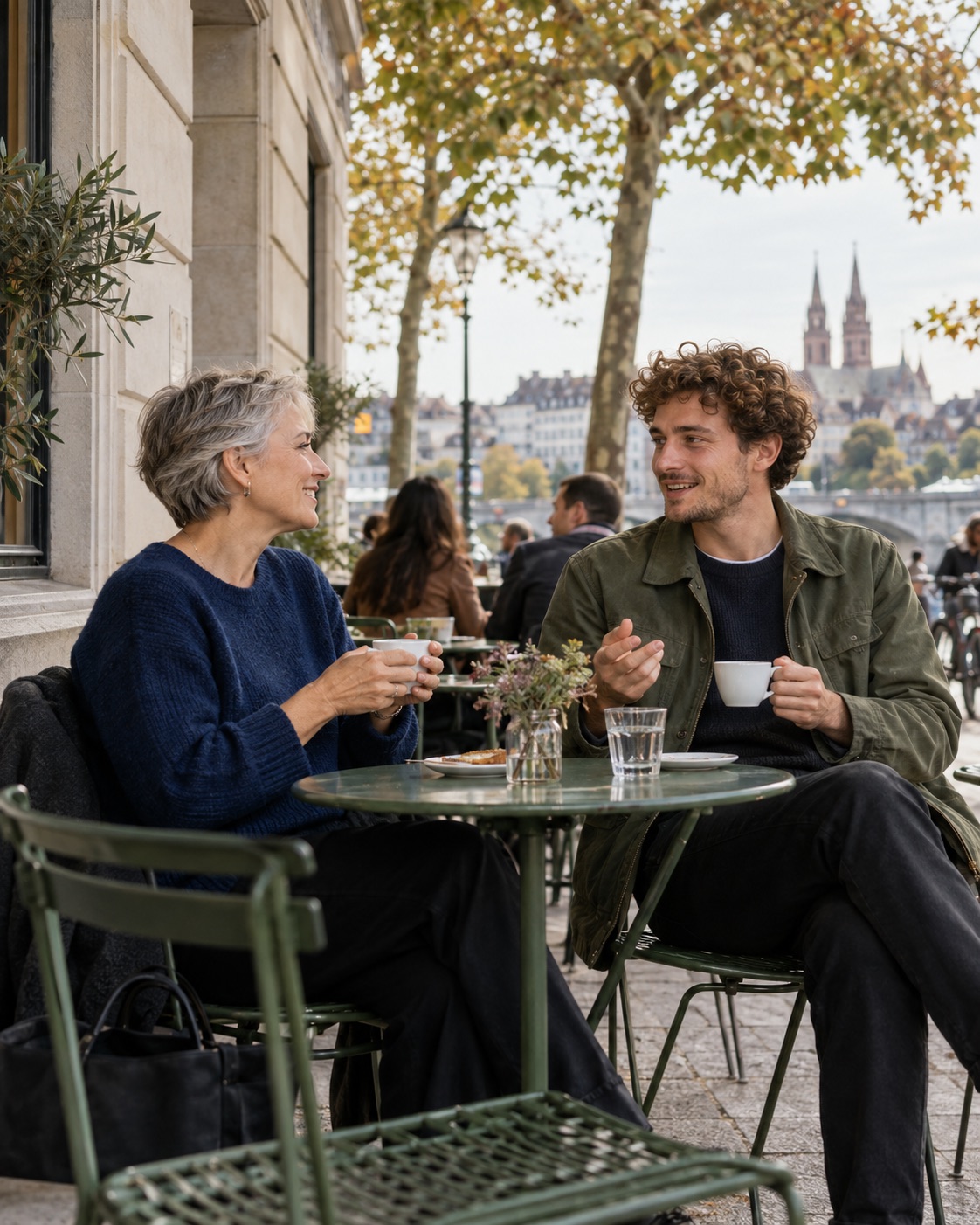 Zwei künftige Kollegen unterhalten sich bei einem Kaffee auf einer Terrasse.